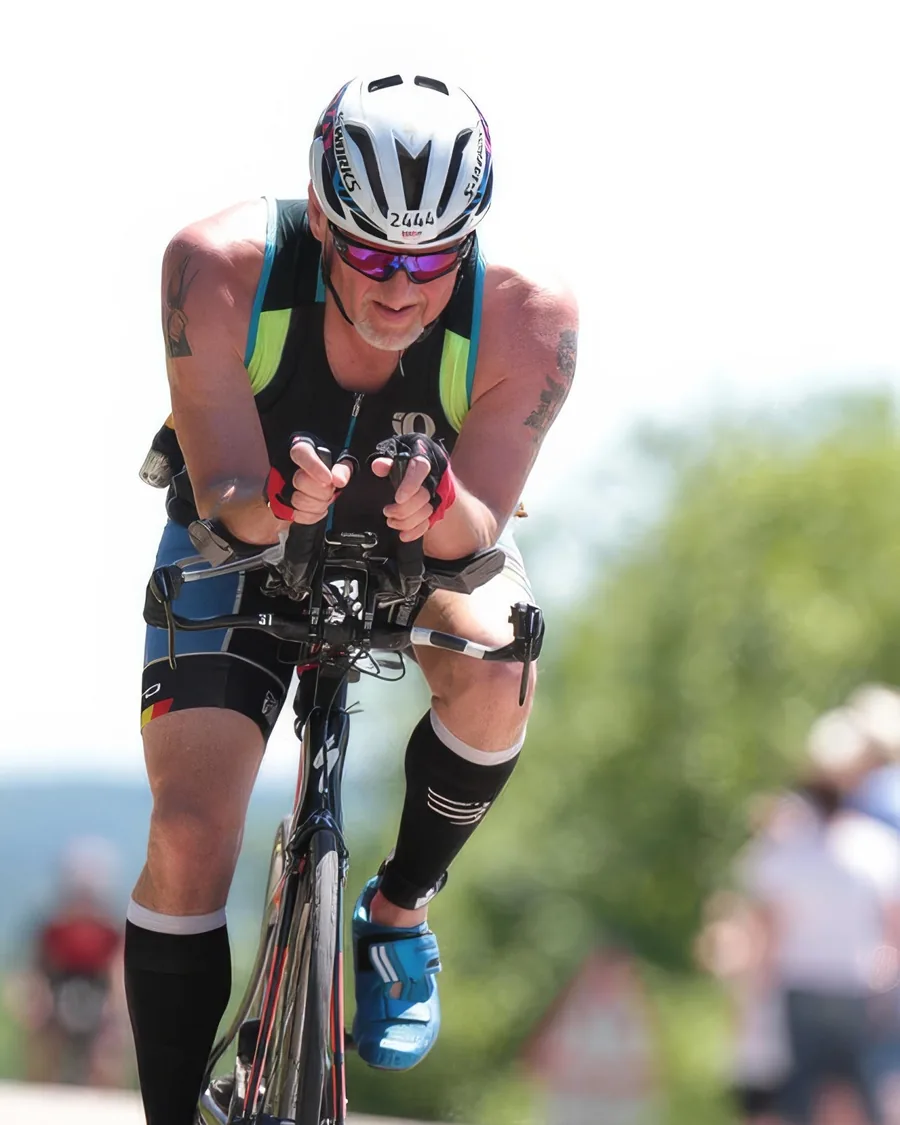 Arthur Mayo racing, low on the aero bars of a time-trial bike in a helmet and sunglasses.