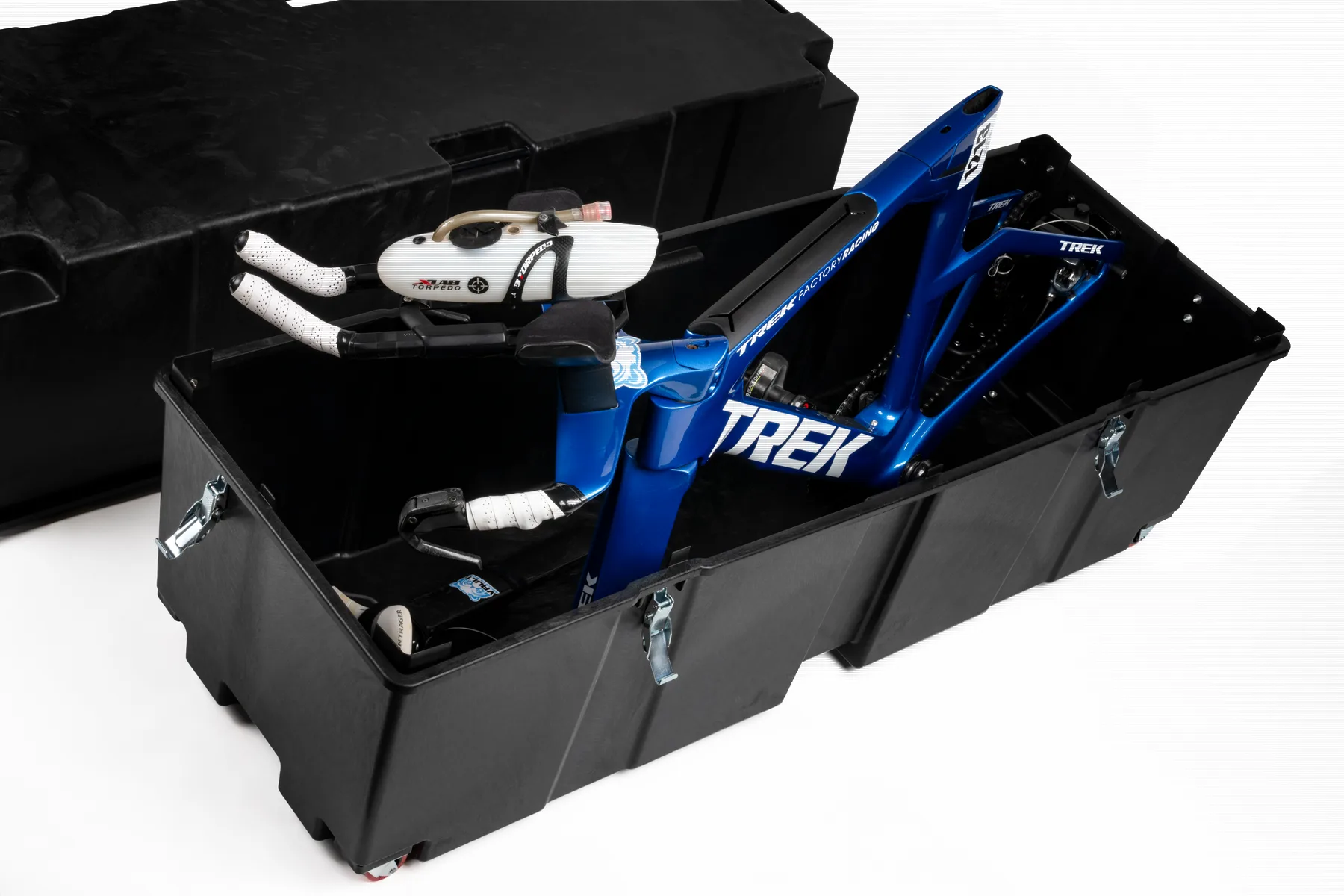 A Vault Pro open with a blue Trek time-trial bike locked inside, lid set beside it, on a white studio background